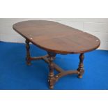 A good quality reproduction oak draw-out extending dining table, of rounded rectangular for, with