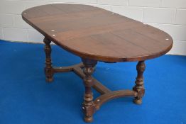 A good quality reproduction oak draw-out extending dining table, of rounded rectangular for, with