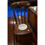 A traditional stained frame child's commode chair with enamel dish