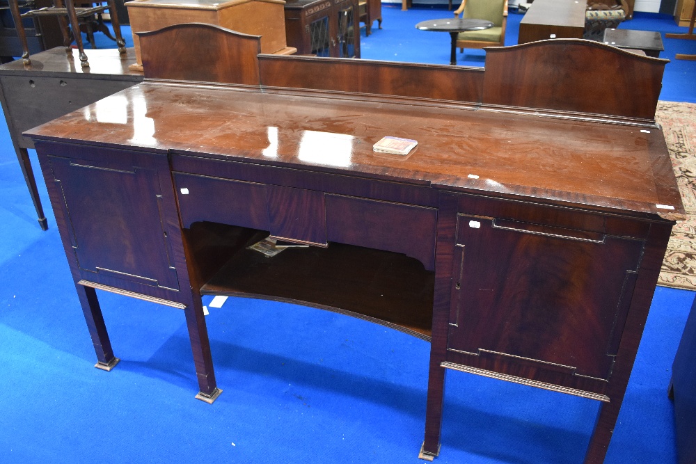 A late 19th or early 20th Century mahogany sideboard having central drawer and shelf, flanked by