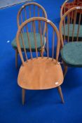 A set of four Ercol hoop and stick back chairs, with seat cushions and H stretchers, in light stain