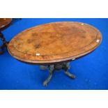 A 19th Century walnut occasional table having quarter veneered top, turned column and quadruple