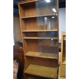 An Arts and Crafts style golden oak bookshelf, with glass to top section