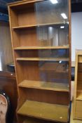 An Arts and Crafts style golden oak bookshelf, with glass to top section