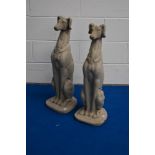 A pair of cast composite garden ornaments, formed as seated Greyhounds, one with damage to one ear