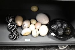 A collection of polished stone 'eggs' in bowl, three graduated paperweights etc
