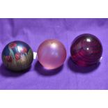 Three spherical art glass paperweights, to comprise a Caithness Tartan Twirl patterned