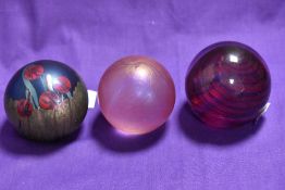 Three spherical art glass paperweights, to comprise a Caithness Tartan Twirl patterned