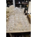 A collection of cut glass wine glasses, liquor glasses, jug, decanter and vase, including Bohemia