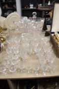 A collection of cut glass wine glasses, liquor glasses, jug, decanter and vase, including Bohemia