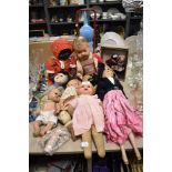 A variety of vintage dolls, including 1930s cloth faced doll, wooden and early plastic examples.