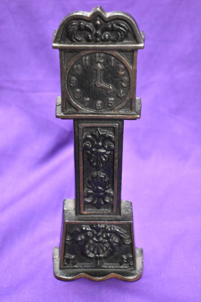 A cast metal penny bank, modelled as long case clock