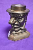 A 19th Century cast iron tobacco jar ,modelled as a dour faced man with lift lid hat.