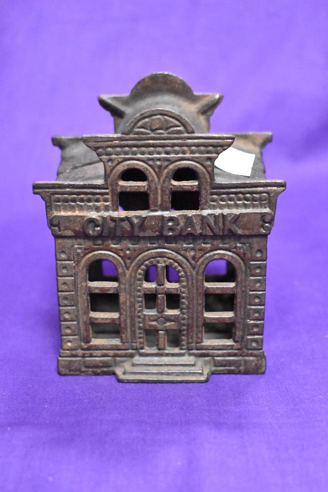 A novelty cast metal penny bank, modelled as city bank