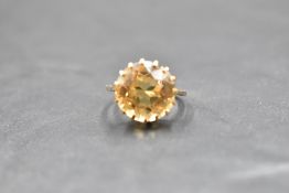 A citrine solitaire ring having a claw set basket mount on a yellow metal loop, no marks tests as