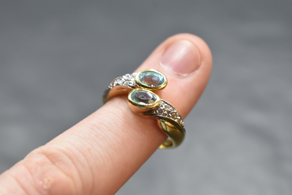An 18ct gold open crossover ring having oval blue topaz to terminals and white stones to - Image 2 of 2