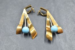 A pair of 18ct gold stud earrings having stylised paired drops with turquoise bead decoration and
