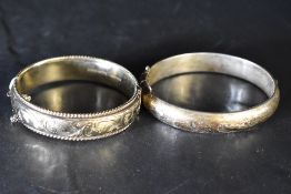 Two HM silver hinged bangles, both having engraved scroll decoration, approx 62g