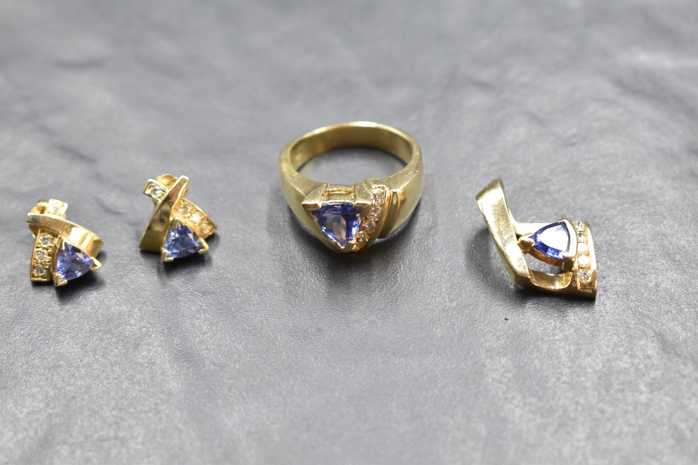 A yellow metal suite of jewellery stamped 14K comprising of stud earrings, ring and pendant, all