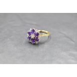 An amethyst and diamond daisy cluster ring having claw set basket mount and 18ct gold loop, size S &