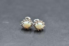 A pair of 14ct white gold opal and diamond chip stud earrings, approx 2.9g