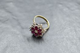 A multi cluster ring having a central diamond surrounded by six oval rubies in petal form within a