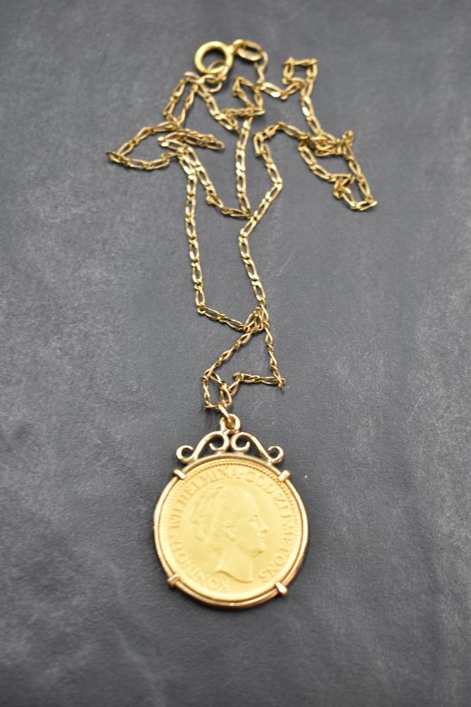 A 10 Guilders (Gulden) Netherlands gold coin in a removable gold mount on a 9ct gold chain, approx