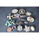 A selection of silver and white metal brooches, several stamped silver including malachite, murano