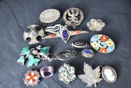 A selection of silver and white metal brooches, several stamped silver including malachite, murano