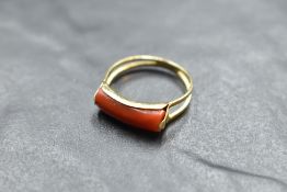 An Italian 750 grade yellow metal and coral ring, the shaped coral section between open the open and