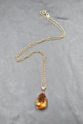 A 9ct gold pendant and chain having a pear drop shaped blue citrine in a claw set mount on a fine