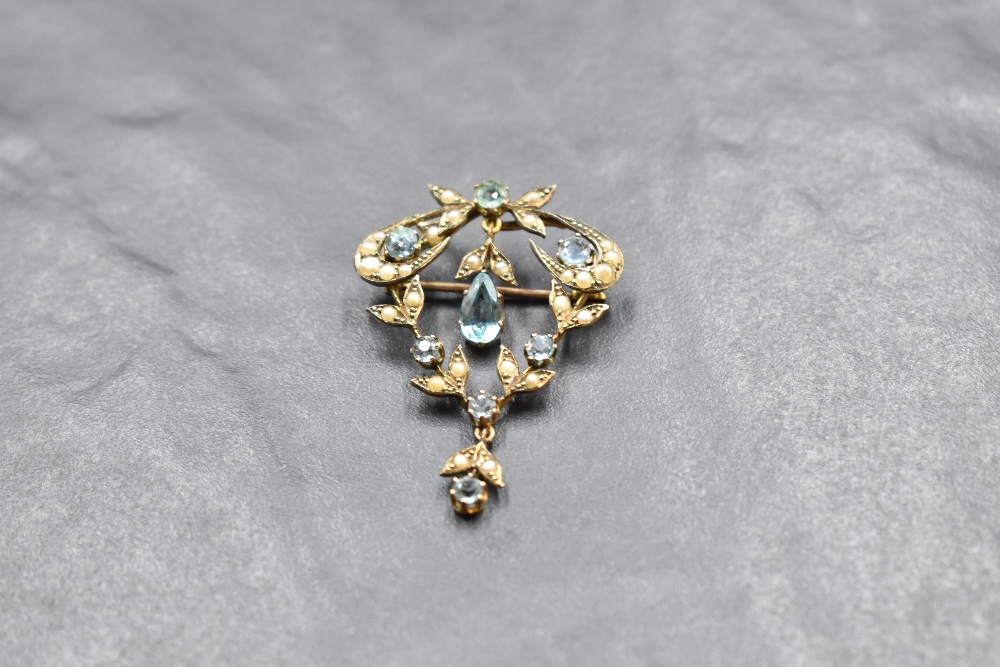 An Edwardian yellow metal pendant/brooch stamped 9ct having blue paste gems and split pearl