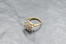 A seven stone diamond daisy cluster ring, total approx 1.5ct, in a raised claw set basket mount on