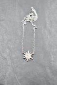 A silver necklace by Fei Lui having a cubic zirconia set multi point star on a fixed chain