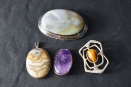 Four pieces of polished stone and silver jewellery including three brooches and a pendant