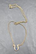A 9ct gold necklace by Sidney Beddall of Ambleside having a sapphire set horseshoe on a fixed chain,