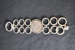 A 1970's HM silver bracelet of stylised form having concealed clasp and bearing makers mark PW,