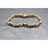 A 9ct white and yellow gold articulated bracelet having 12 white gold lozenge panels, each