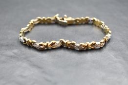A 9ct white and yellow gold articulated bracelet having 12 white gold lozenge panels, each