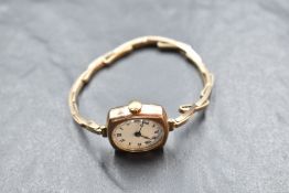 A lady's vintage 9ct rose gold wrist watch having Roman numeral dial to white face in a plain case