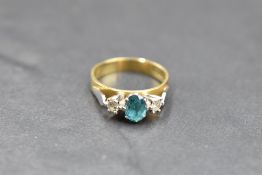 A blue topaz and diamond trio ring having an oval topaz flanked by two diamonds each approx 0.