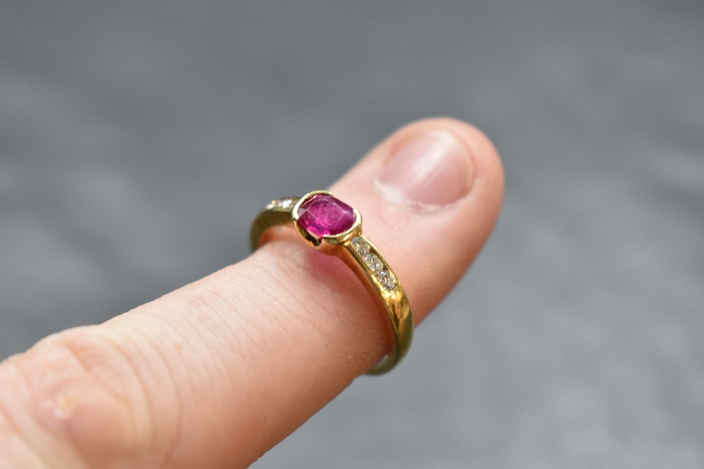 A ruby and diamond ring having a central oval ruby having diamond set shoulders on an 18ct gold - Image 2 of 2