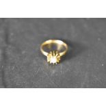 A diamond solitaire ring, approx 0.125ct in a 4 claw set stylised star burst mount on an 18ct gold