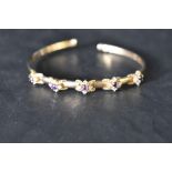 A 9ct gold tension bangle having amethyst and cubic zirconia decoration, approx 8.8g
