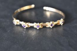 A 9ct gold tension bangle having amethyst and cubic zirconia decoration, approx 8.8g