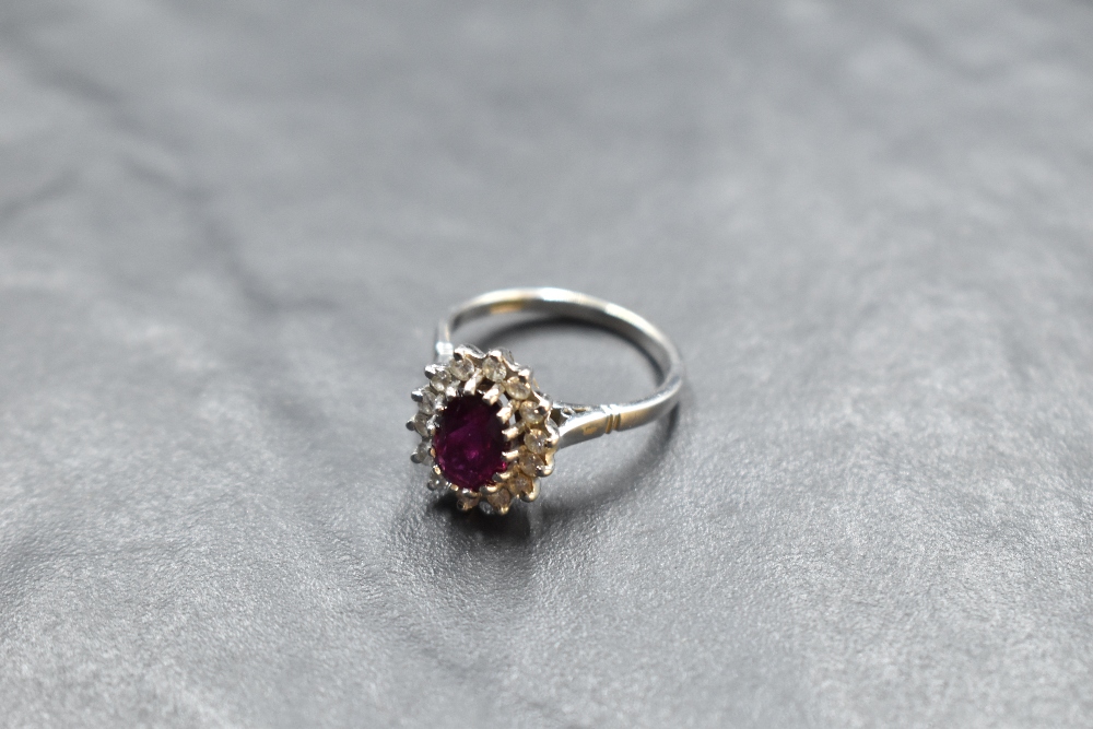 A ruby and diamond cluster ring in a claw set stepped mount on an 18ct white gold loop, size M &