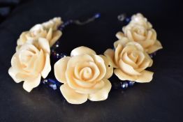 A Butler & Wilson 1980's statement collarette necklace having nine graduated roses on wire beaded
