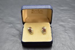 A pair of 9ct gold stud earrings having ruby and diamond chip decoration to moulded panels, approx