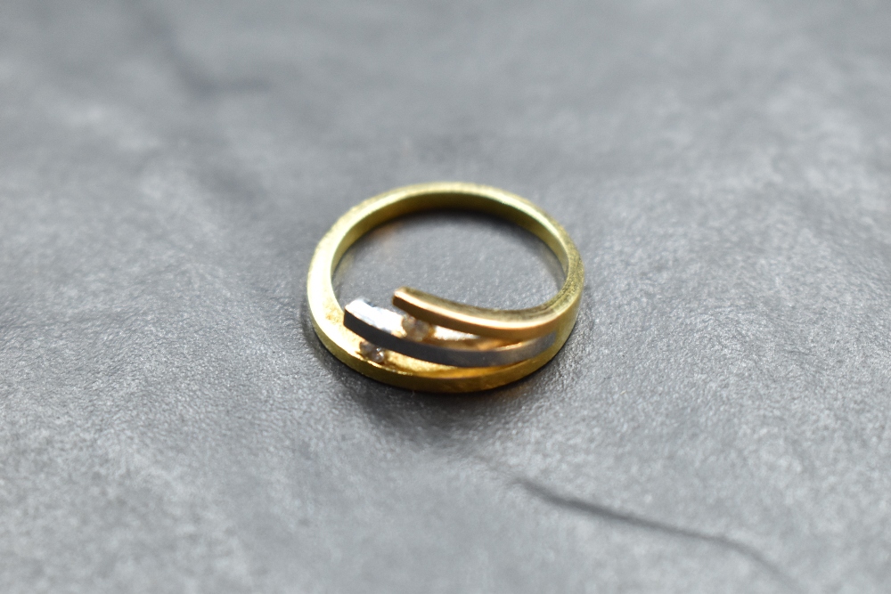 A two tone 750 grade white and yellow metal diamond set ring, the yellow metal band issuing a
