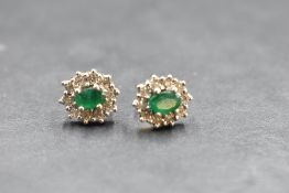 A pair of 9ct gold stud earrings having emerald style and diamond chip clusters, approx 3g gross